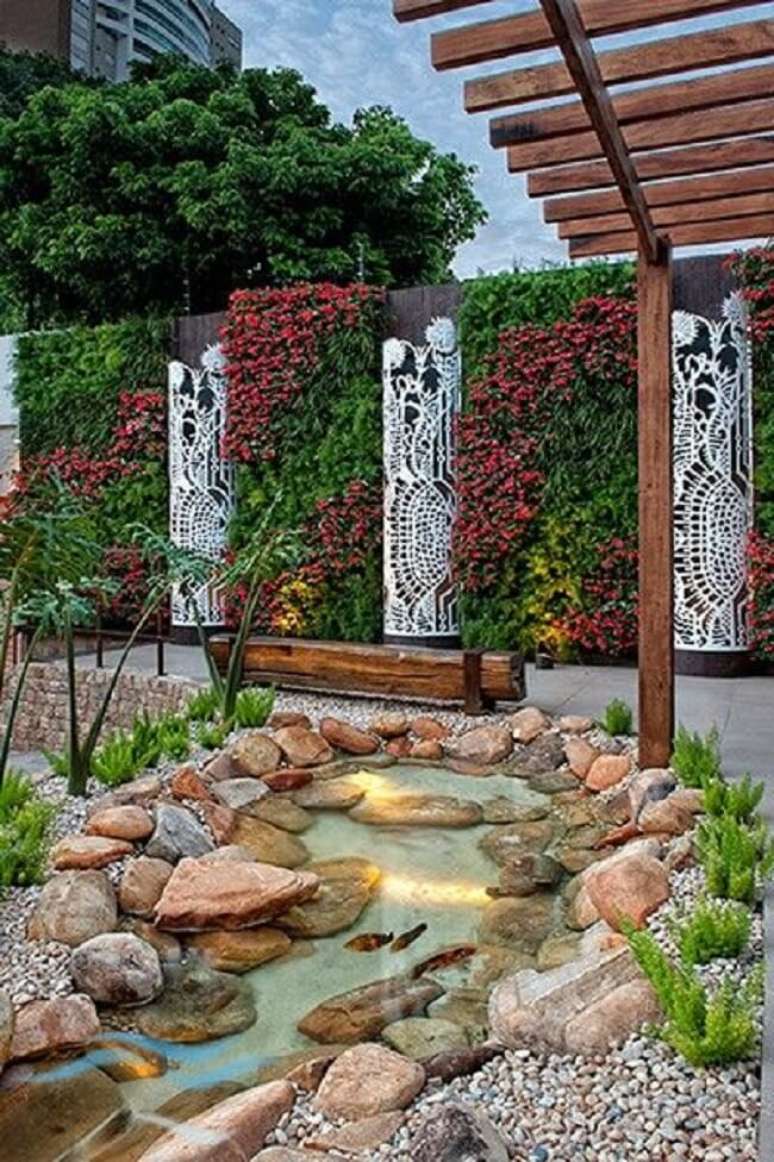 41. Lago ornamental pequeno com pedras naturais e banco de madeira. Fonte &ndash; Marina Fodra