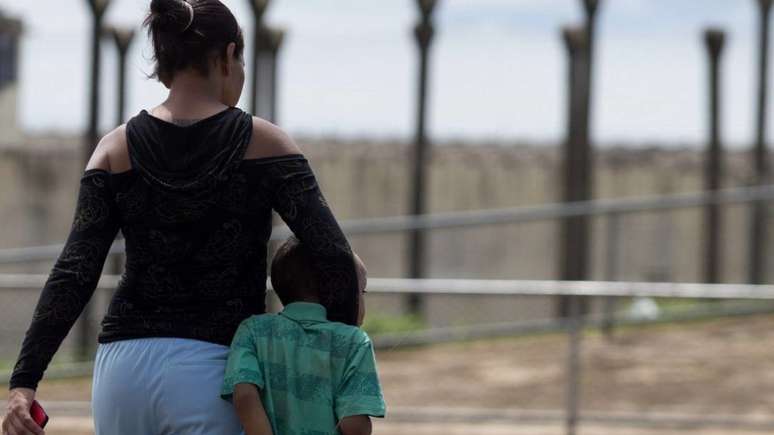 Imagem mostra mãe negra com o filho a caminho da visita em presídio, como fazem muitas mulheres negras, as principais vítimas de constrangimentos.