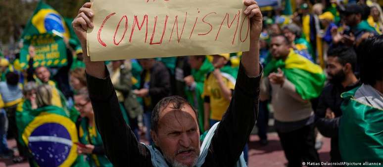 Apoiador do presidente Jair Bolsonaro levanta cartaz onde est&aacute; escrito "n&atilde;o ao comunismo" durante protesto contra a derrota do mandat&aacute;rio na elei&ccedil;&atilde;o presidencial de 2022, em S&atilde;o Paulo.
