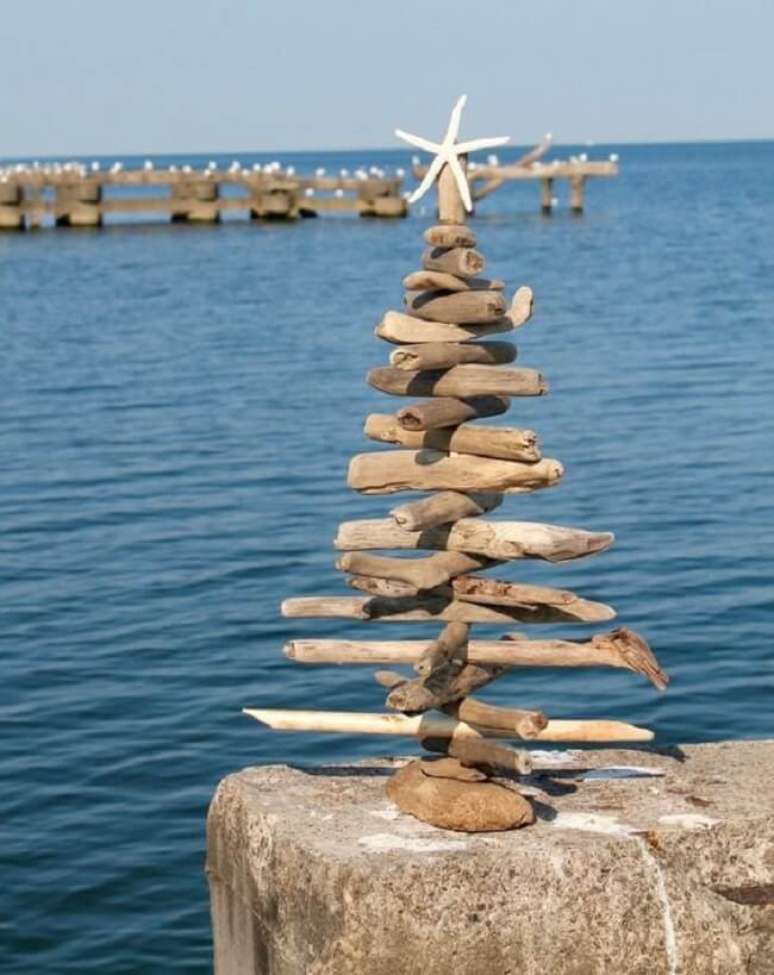47. No topo a estrela do mar deixa a &aacute;rvore de natal de madeira ainda mais linda. Fonte &ndash; Etsy