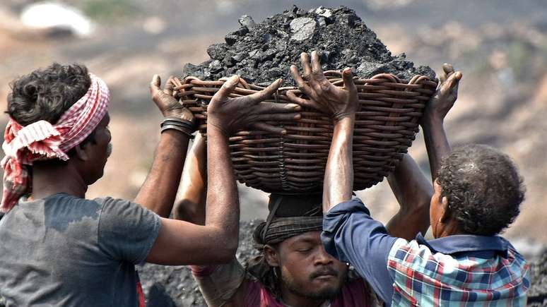 Trabalhadores carregam carv&atilde;o no campo de Jharia em Dhanbad, no Estado de Jharkhand, na &Iacute;ndia