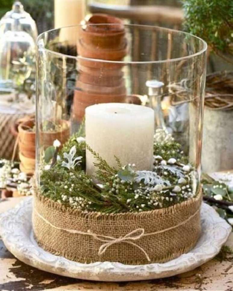 22. Arranjos de natal em vasos de vidro com flores, vela e faixa de tecido juta. Fonte &ndash; Casa Abril