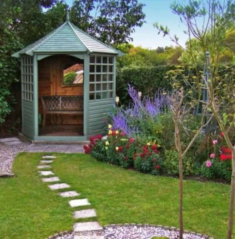 17. A estrutura em madeira com banco foi utilizada como enfeite de jardim nesse espaço. Fonte: Decoratorist