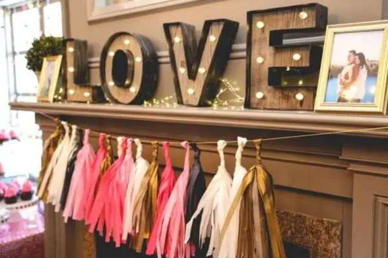 29- No ch&aacute; de casa nova, a lareira foi enfeitada com a palavra Love e porta retratos. Fonte: Guia Noiva Online