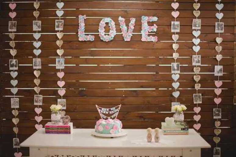 20- Na decora&ccedil;&atilde;o ch&aacute; de casa nova, as fotografias do casal ocupam lugar de destaque atr&aacute;s da mesa. Fonte: Berries and Love