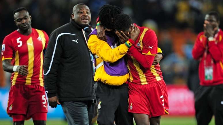 Asamoah Gyan é consolado por companheiros após eliminação na Copa do Mundo de 2010.