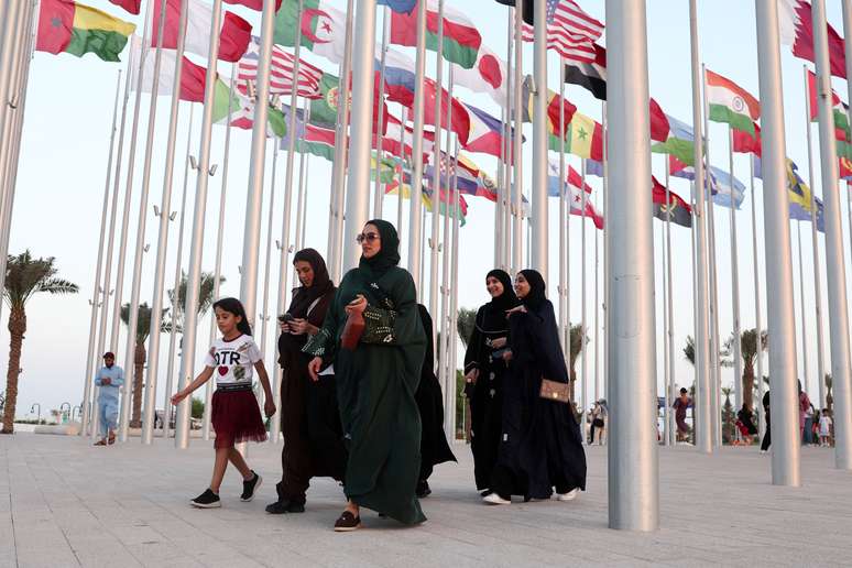 Mulheres caminham pela praça das bandeiras em Doha