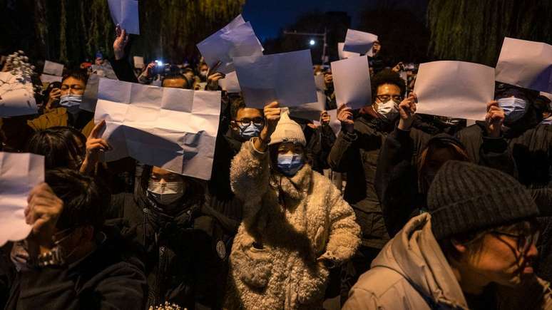 Manifestantes seguram pedaços de papel em branco em Pequim