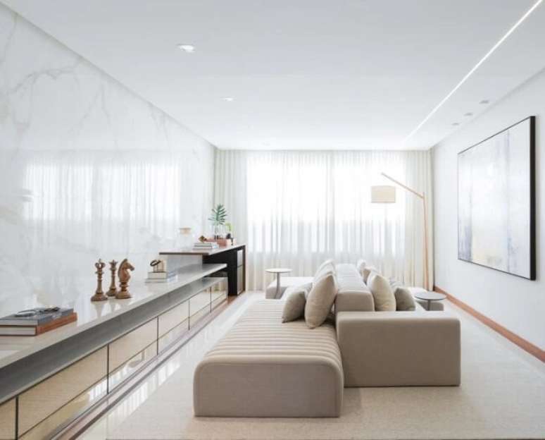 32. Sala com cortinas leves e sof&aacute;-ilha cinza. Fonte &ndash; Onzi.Arq