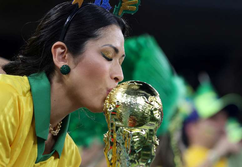 Torcedora brasileira beija r&eacute;plica da ta&ccedil;a da Fifa em partida entre Brasil e Su&iacute;&ccedil;a
