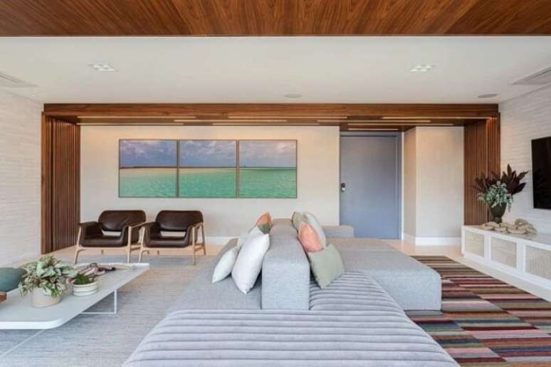 7. Sala com quadro mosaico e sof&aacute;-ilha. Fonte &ndash; Duda Senna Arquitetura