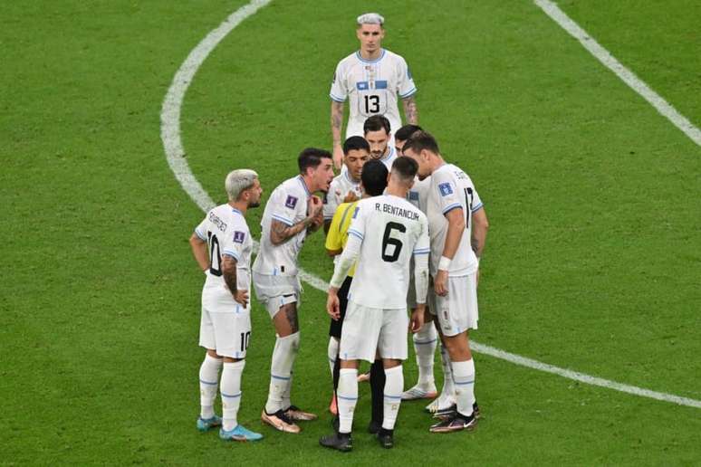 Jogadores uruguaios questionaram a marcação do pênalti (Foto: GLYN KIRK / AFP)