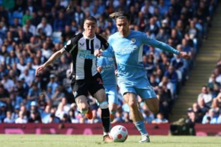 Grealish e Almirón disputam bola em jogo da Premier League (Foto: AFP)