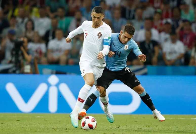 Cristiano Ronaldo dividindo a bola com Torreira, do Uruguai, em 2018 (Foto: ODD ANDERSEN/AFP)