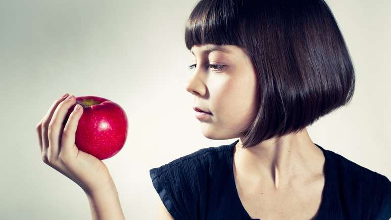 menina segurando ma&ccedil;&atilde;