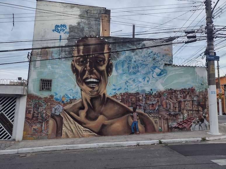 Grafite do grupo OPINI, na Rua Vitório Azzalin, em São Mateus, traz Tia Cida alegre sobre as favelas do bairro @Matheus Oliveira/Agência Mural