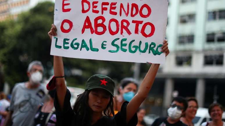 A imagem mostra uma manifestante segurando o cartaz escrito: não sou mãe e defendo o aborta legal e seguro