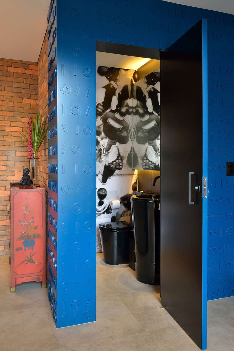 Apesar de não existir na planta original, o lavabo se tornou um dos destaques deste projeto – ele foi executado com um portal em laca azul, com desenhos em relevo, cheio de personalidade | Projeto: Korman Arquitetos.