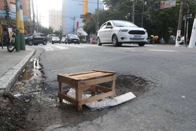 Na rua Teodoro Sampaio, em Pinheiros, um caixote de madeira foi colocado em um buraco na faixa de ônibus ALEX SILVA /ESTADAO