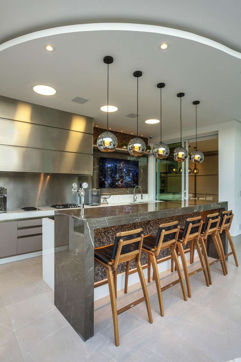 7. Cozinha com bancada de m&aacute;rmore marrom e ilumina&ccedil;&atilde;o chique &ndash; Foto Iara Kilaris