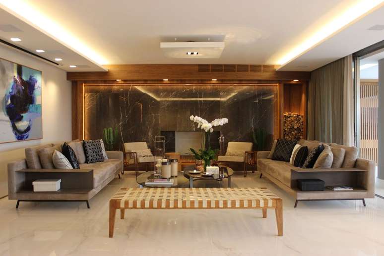 18. Parede revestida com m&aacute;rmore marrom e poltronas bege &ndash; Foto Maricy Marcos Borges