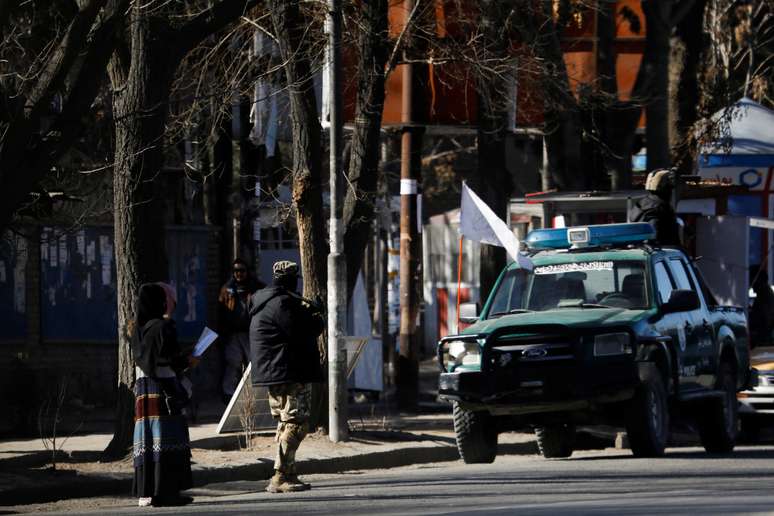 Integrante do Taliban em frente ao portão de entrada da Universidade de Cabul, no Afeganistão