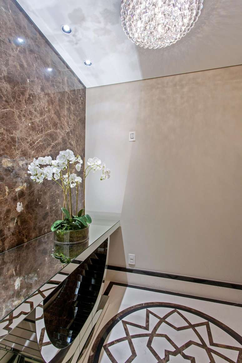 19. Parede com m&aacute;rmore marrom e aparador espelhado &ndash; Foto Iara Kilaris