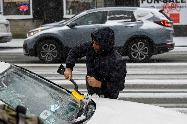 Homem retira neve de carro em Chicago 22/11/2022 