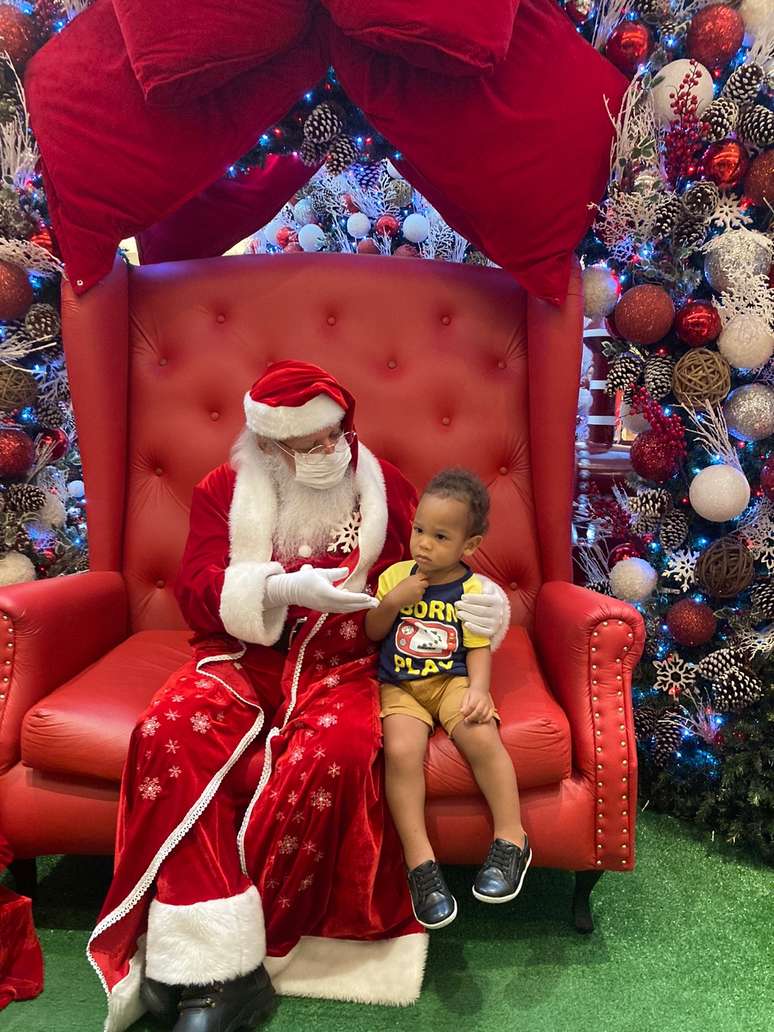 Akin, filho do colunista Luã Andrade, conhece o Papai Noel negro do Parque Shopping