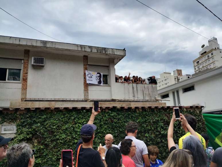 Família ergue bandeira com os dizeres 'Pelé eterno'