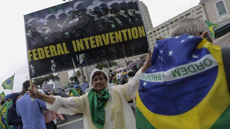 No Rio de Janeiro, apoiadora de Jair Bolsonaro mostra cartaz em inglês pedindo 'intervenção federal'