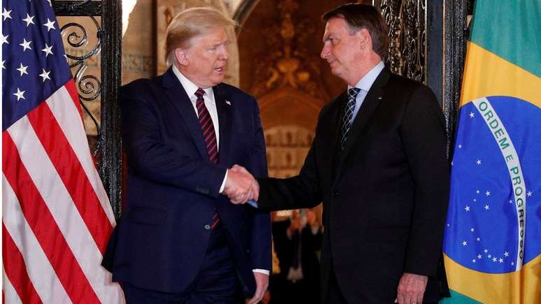 Aperto de mãos entre Donald Trump e Jair Bolsonaro