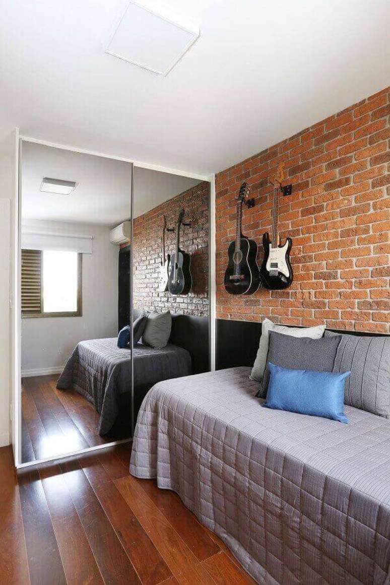 50. Papel de parede para quarto masculino com estampa tijolinho decorado com guarda roupa espelhado &ndash; Foto: Decor F&aacute;cil