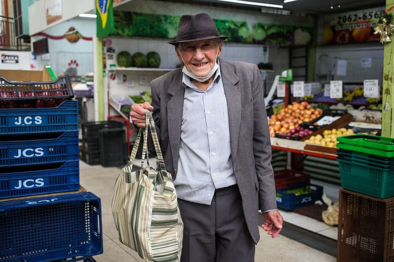 Seu João Leiva, de 82 anos, compra alguns legumes e frutas no mercado.