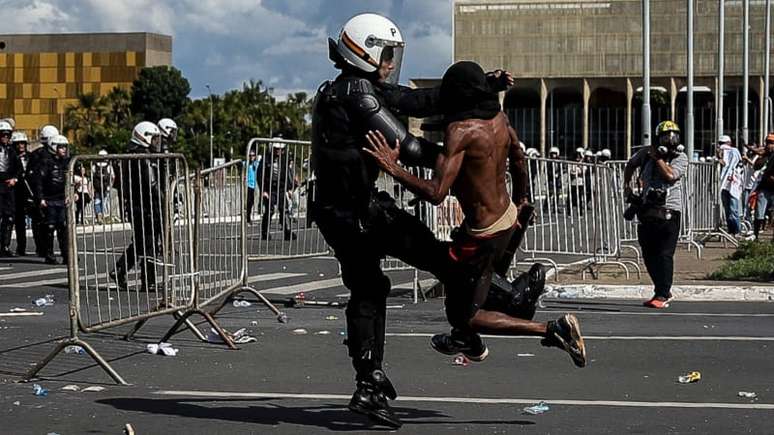 Imagem mostra manifestante negro sendo agredido por policial em manifestação contra o governo Temer, em 2017.