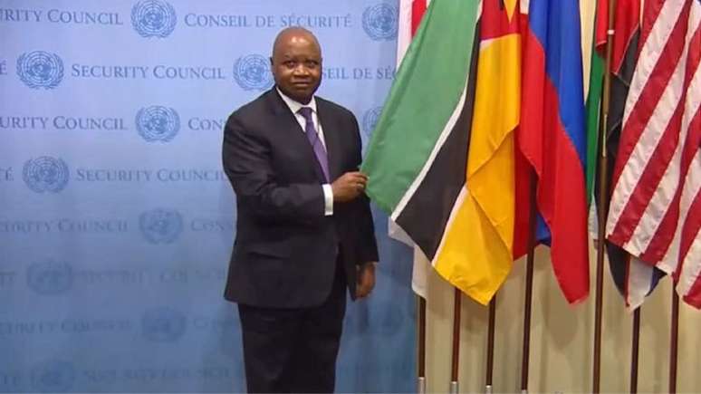 Imagem de Pedro Comissário segurando bandeira de Moçambique no Conselho de Segurança da ONU.