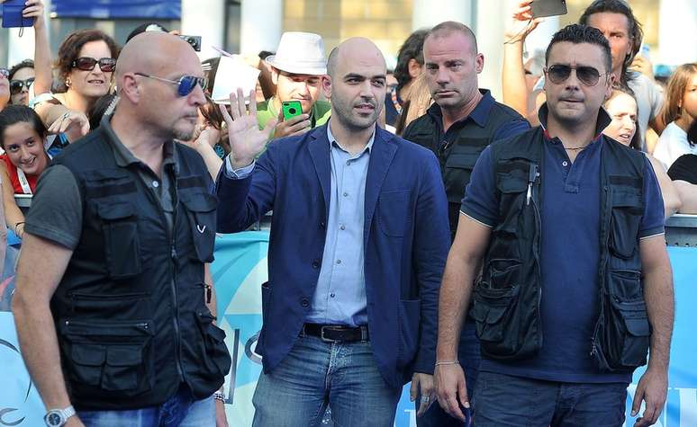 Três guarda-costas protegem o jornalista Roberto Saviano (centro), que recebeu ameaças de morte pela publicação de seu livro "Gomorra", que trata da máfia napolitana.