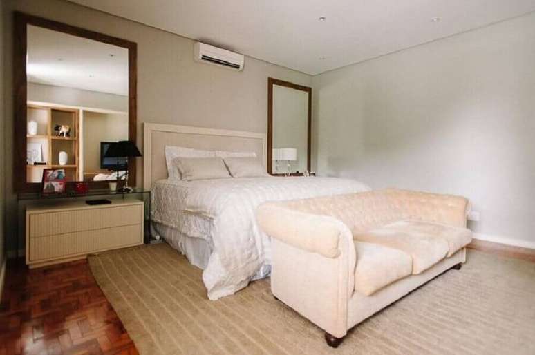 30. Decora&ccedil;&atilde;o de quarto de casal com espelho grande com moldura de madeira &ndash; Foto: OKKA