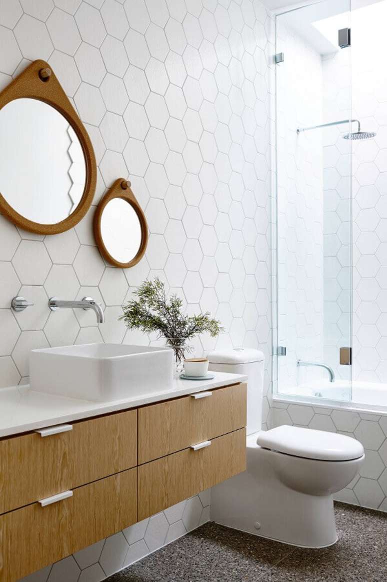 40. Espelho com moldura de madeira para banheiro branco decorado com revestimento hexagonal &ndash; Foto: HomeWorldDesign