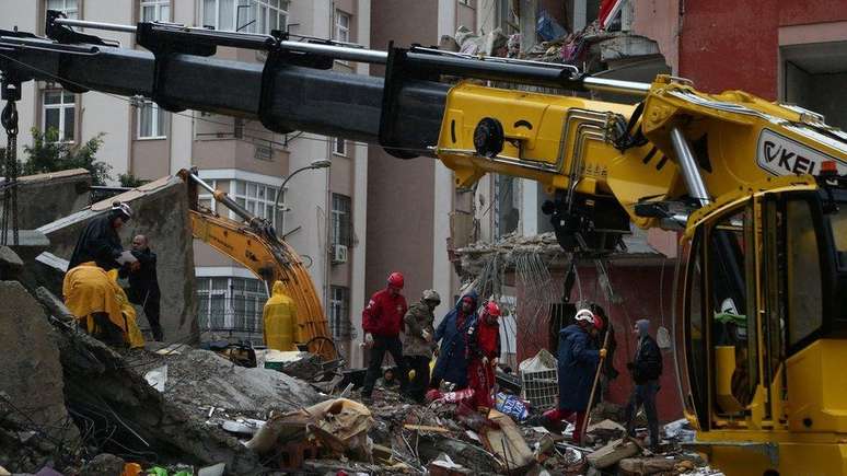 Equipes de resgate trabalham no local de um prédio desabado em Adana, Turquia
