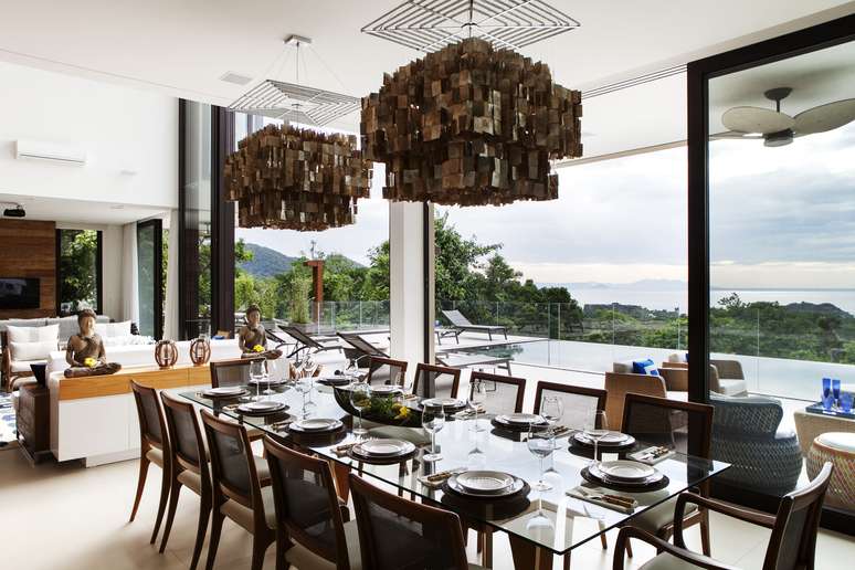 A Sala de jantar, integrada com os outros c&ocirc;modos, traz uma decora&ccedil;&atilde;o &uacute;nica e personalizada. Os pendentes feitos a m&atilde;o de madrep&eacute;rola vindos da Indon&eacute;sia chamam a aten&ccedil;&atilde;o e s&atilde;o o destaque ambiente.