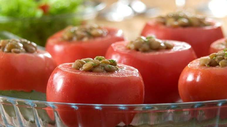 Tomates recheados com lentilha em travessa transparente