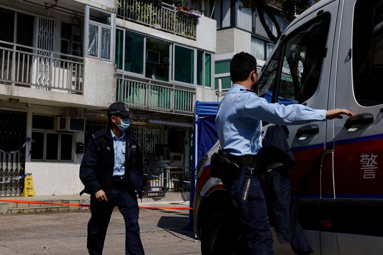 Policiais se re&uacute;nem fora de edif&iacute;cio onde foram encontrados restos mortais de mulher assassinada, em Hong Kong