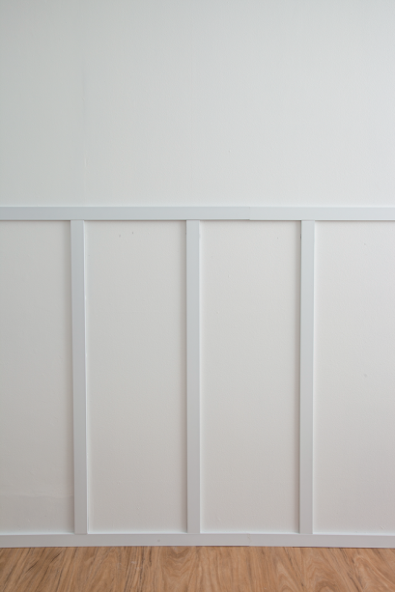 The upper part of the boiserie is finished with the same casing used for the vertical slats, but cut according to the horizontal extension of the wall.  The harmony of the set comes from using pieces of the same width, as well as the exact intervals between them.