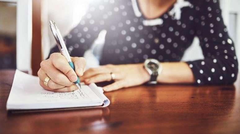 Woman writing in notebook on the table