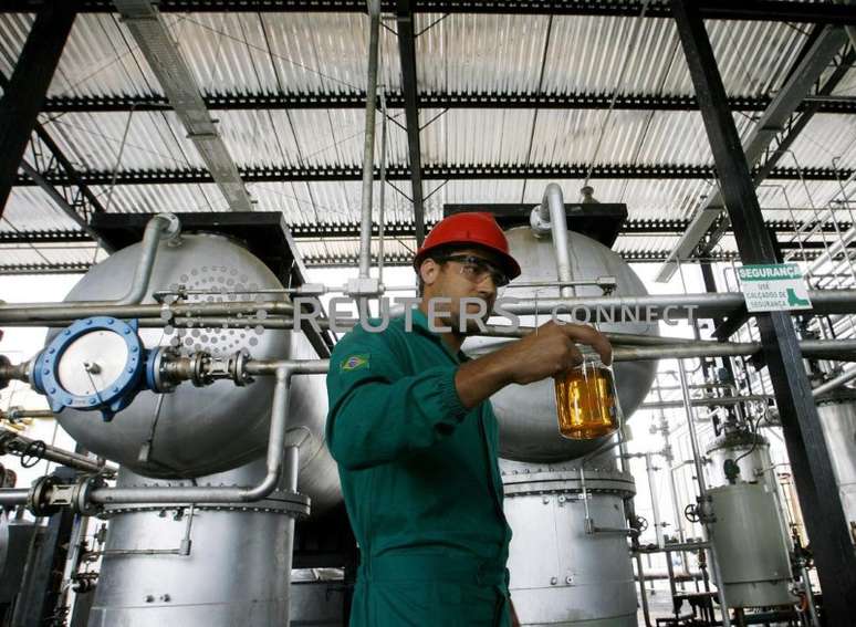 A worker shows a sample of biodiesel made from castor beans at a biodiesel refinery in Iraquara, 310 miles (500 km) west of the Bahia state capital, Salvador March 31, 2008. Investors, including many foreigners, have flocked to Brazil's hinterland with its enormous farm potential and some of the world's lowest costs to produce biofuels. Picture taken March 31, 2008. REUTERS/Jamil Bittar (BRAZIL)