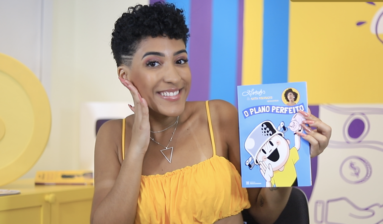 Nath Financças is holding his new book and smiling
