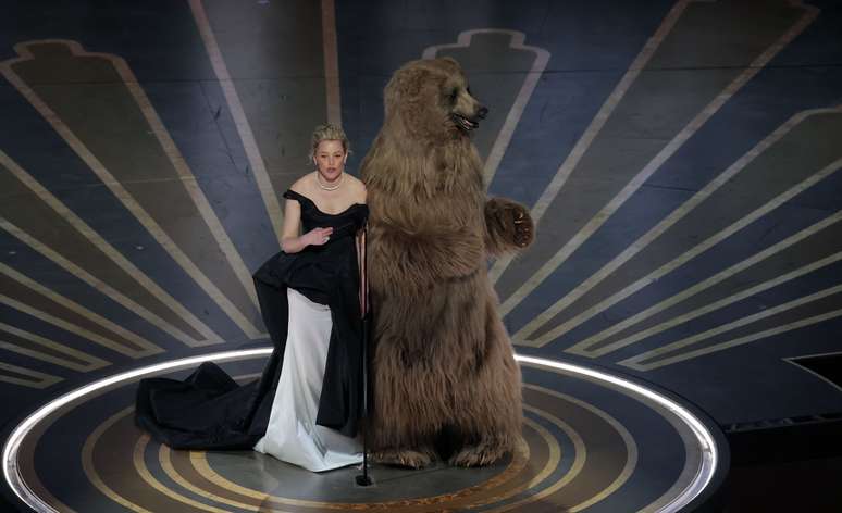Elizabeth Banks e o urso de Cocaine Bear no palco do Oscar 