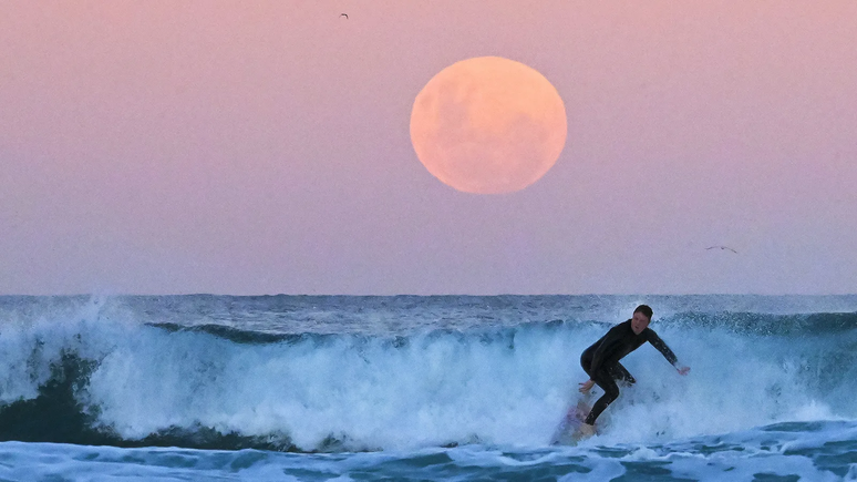 A força gravitacional da Lua sobre os oceanos da Terra cria as marés, que arrastam a Lua para uma órbita mais alta