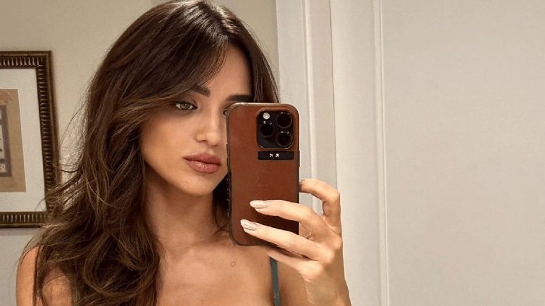 Rafa Kalimann poses with a plunging neckline and shows off his body in a skintight dress